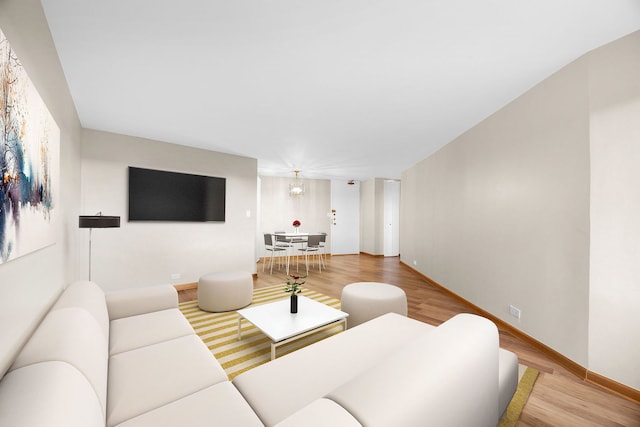 living room with hardwood / wood-style flooring and a notable chandelier