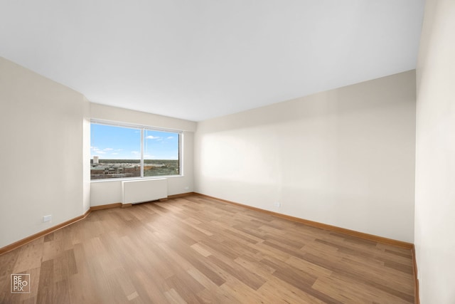 spare room with light hardwood / wood-style flooring and radiator