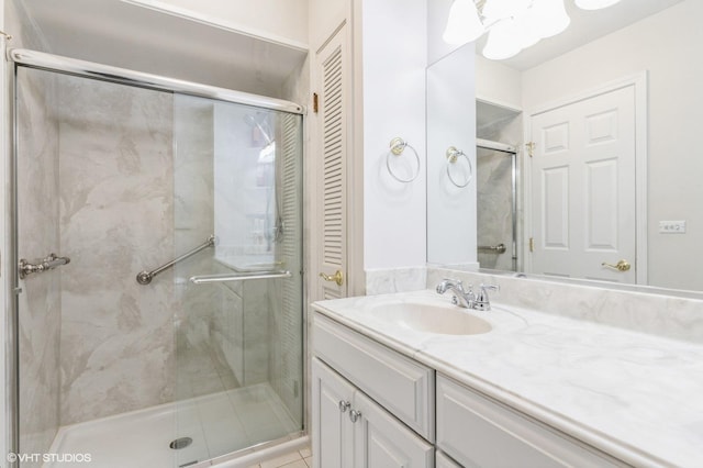 bathroom with tile patterned flooring, vanity, and a shower with door