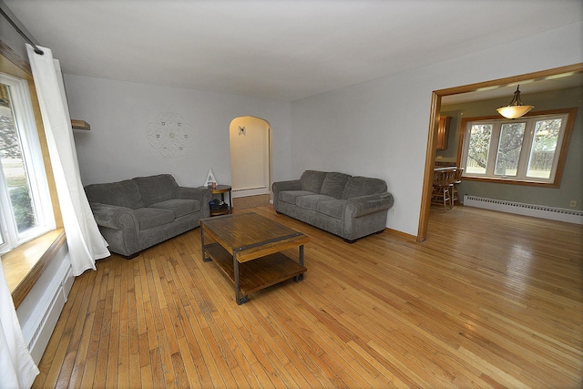 living room with baseboard heating and light hardwood / wood-style flooring