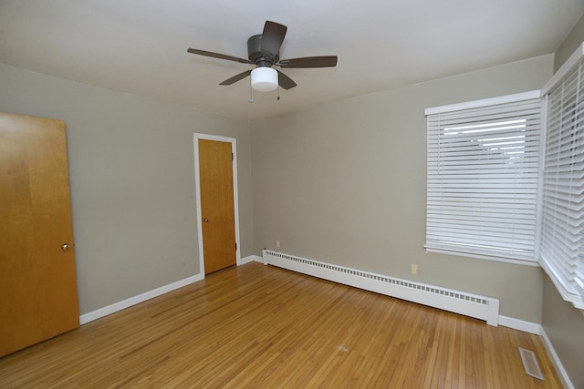 unfurnished room with ceiling fan, wood-type flooring, and a baseboard radiator