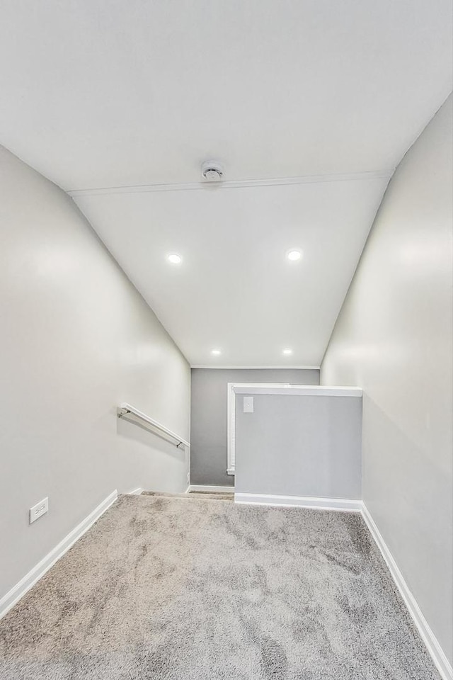 carpeted spare room featuring vaulted ceiling