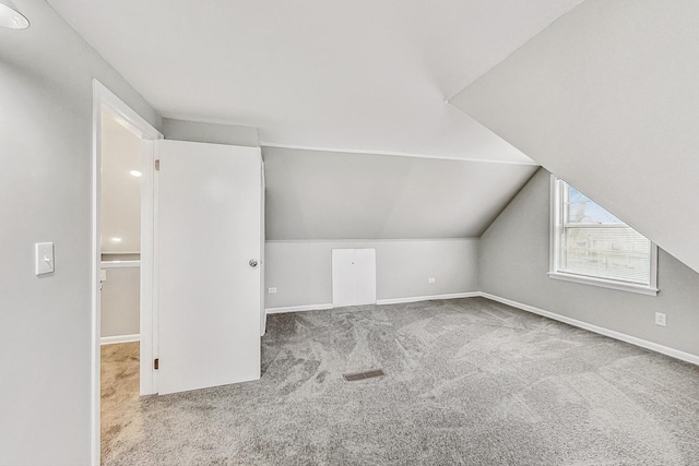 bonus room featuring light colored carpet and lofted ceiling