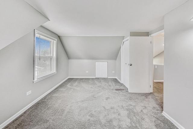 bonus room featuring light colored carpet and vaulted ceiling