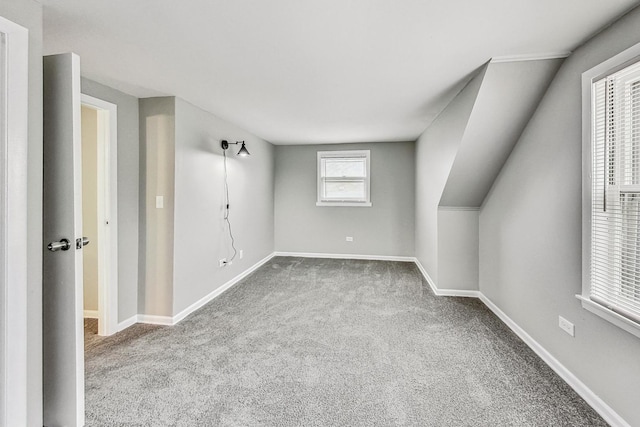 interior space featuring light carpet and vaulted ceiling