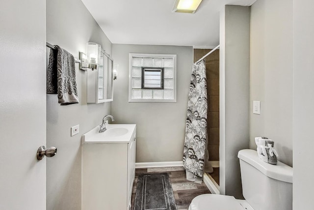 bathroom featuring hardwood / wood-style flooring, vanity, curtained shower, and toilet