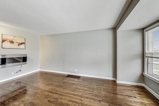 unfurnished living room with dark wood-type flooring