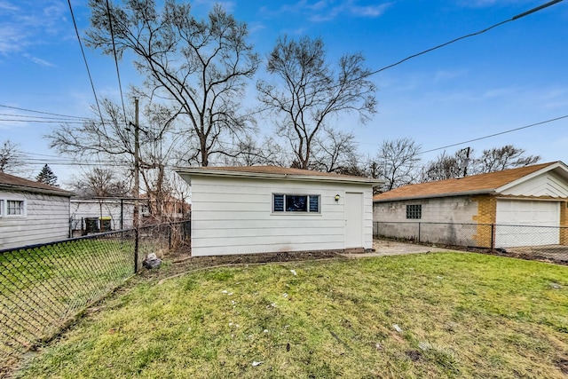 rear view of house featuring a lawn and an outdoor structure