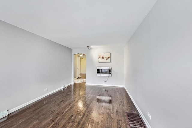 unfurnished living room featuring heating unit and dark wood-type flooring