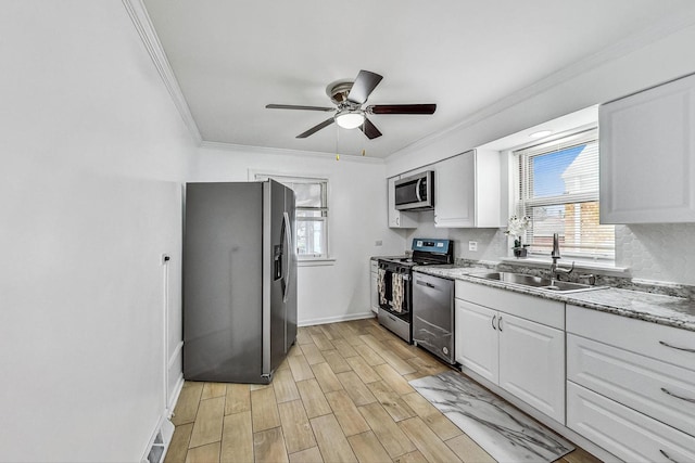 kitchen with stainless steel appliances, white cabinetry, light hardwood / wood-style floors, and sink