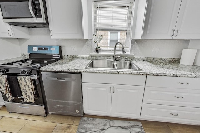 kitchen with white cabinets, light stone countertops, sink, and appliances with stainless steel finishes