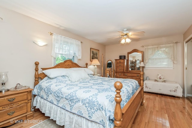 bedroom with multiple windows, ceiling fan, and light hardwood / wood-style floors