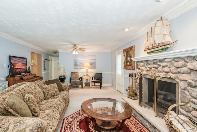 living room featuring light carpet, ornamental molding, a textured ceiling, ceiling fan, and a stone fireplace