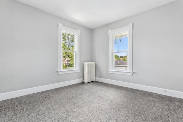 carpeted spare room with radiator heating unit