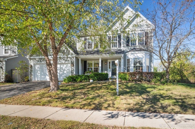 view of front facade with a front yard, a garage, and driveway