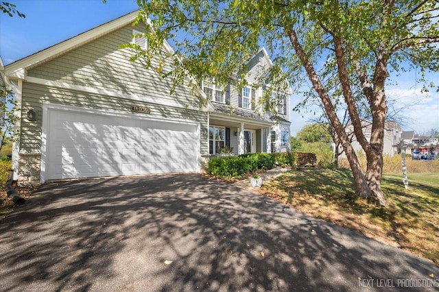 view of front of property with aphalt driveway and a garage