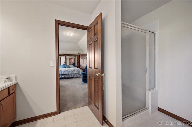 ensuite bathroom with tile patterned flooring, a shower stall, connected bathroom, baseboards, and vanity