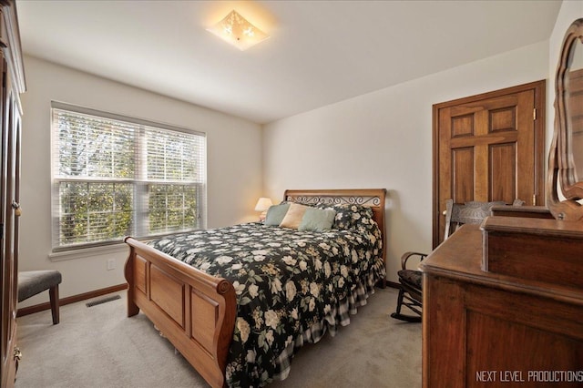 bedroom with visible vents, light colored carpet, and baseboards