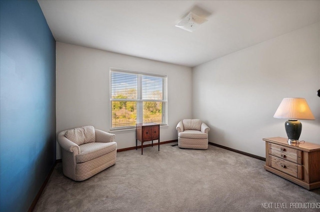 sitting room with baseboards and carpet