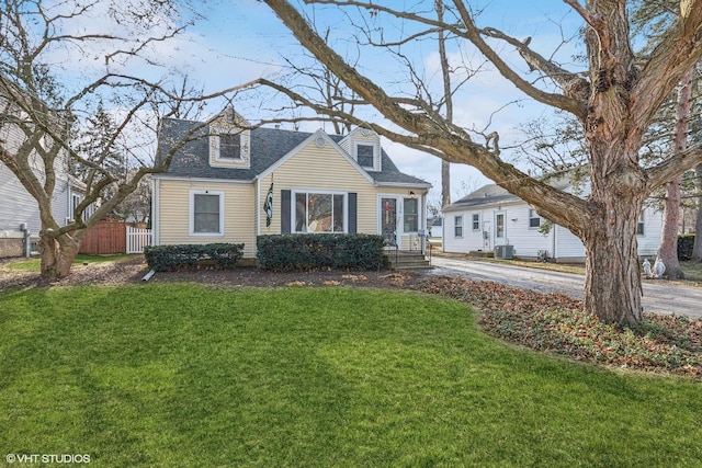 cape cod house featuring a front yard and central AC unit