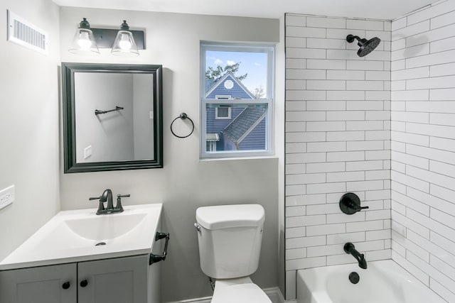 full bathroom with toilet, vanity, and tiled shower / bath