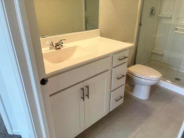 bathroom with toilet, vanity, tile patterned floors, and walk in shower