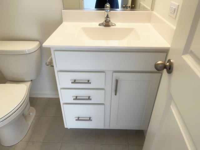 bathroom with tile patterned flooring, vanity, and toilet