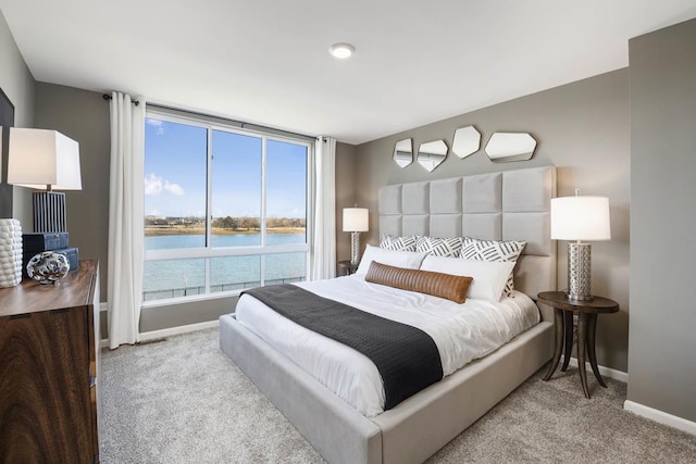 carpeted bedroom featuring a water view