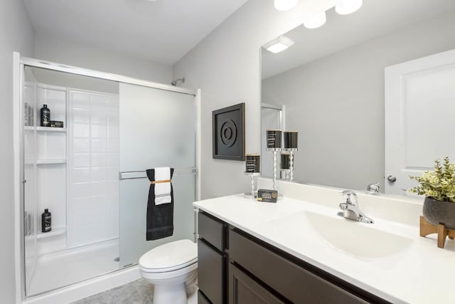 bathroom with tile patterned flooring, vanity, toilet, and an enclosed shower