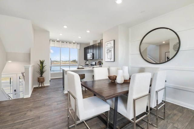 dining room with a water view and dark hardwood / wood-style floors