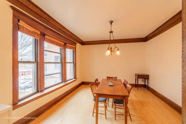 dining space featuring hardwood / wood-style flooring, crown molding, and a notable chandelier