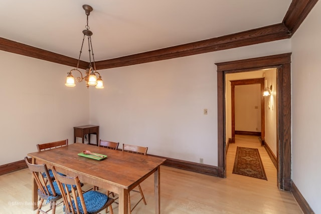 dining room with ornamental molding, a chandelier, and light wood-type flooring