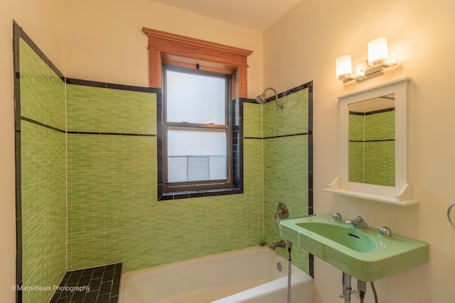 bathroom featuring tiled shower / bath combo and sink