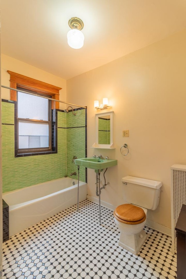 bathroom featuring radiator, toilet, and tiled shower / bath