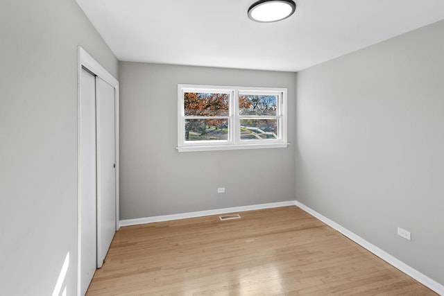 unfurnished bedroom featuring light hardwood / wood-style flooring and a closet