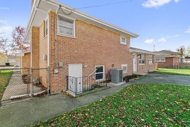 rear view of property with a yard and central AC unit