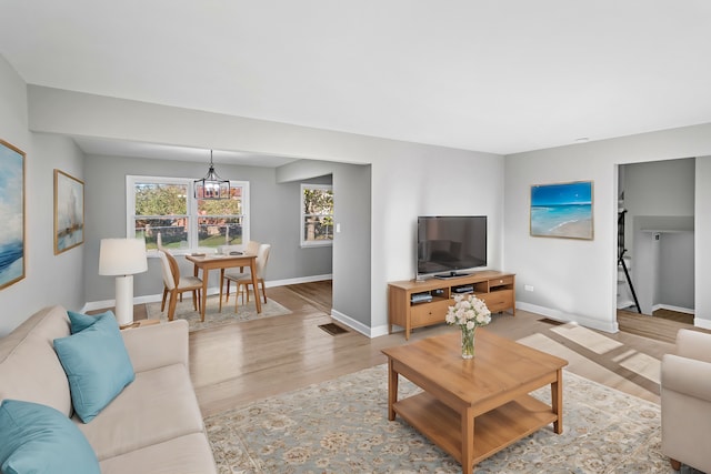 living room featuring light hardwood / wood-style flooring and a notable chandelier