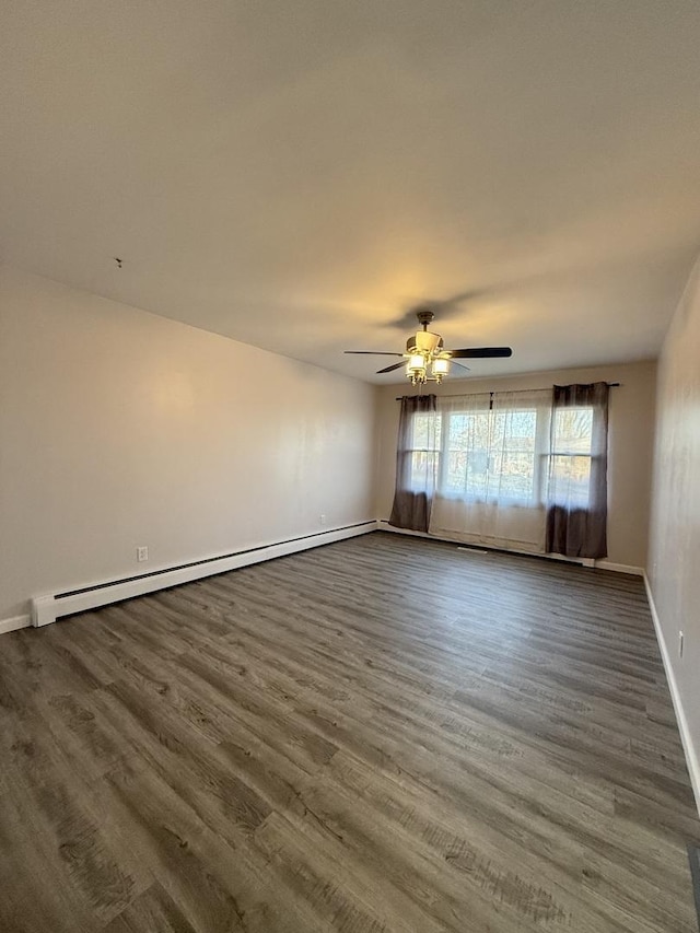 unfurnished room featuring dark hardwood / wood-style floors, baseboard heating, and ceiling fan