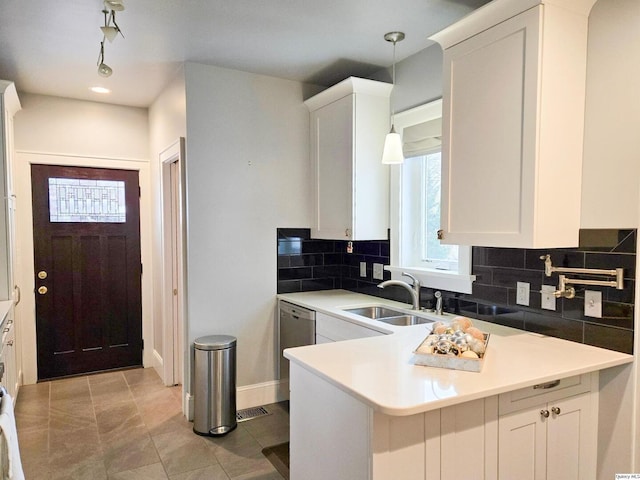 kitchen with hanging light fixtures, dishwasher, sink, and white cabinets