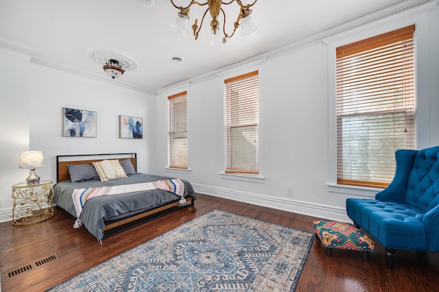 bedroom with multiple windows, crown molding, wood-type flooring, and an inviting chandelier