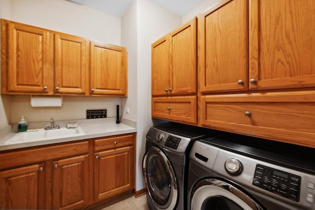 laundry room featuring sink, light tile patterned floors, washing machine and dryer, and cabinets