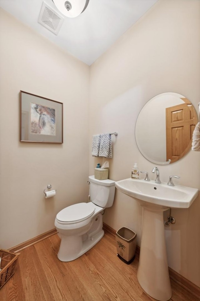 bathroom with hardwood / wood-style flooring and toilet