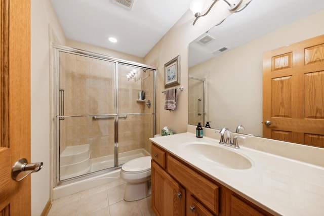 bathroom with tile patterned floors, toilet, a shower with door, and vanity