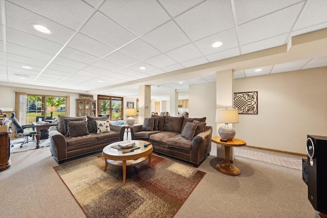 carpeted living room featuring a drop ceiling