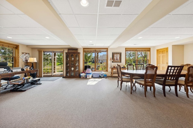 dining space with carpet and a drop ceiling