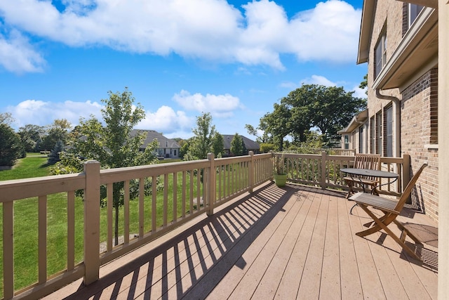 wooden terrace featuring a lawn