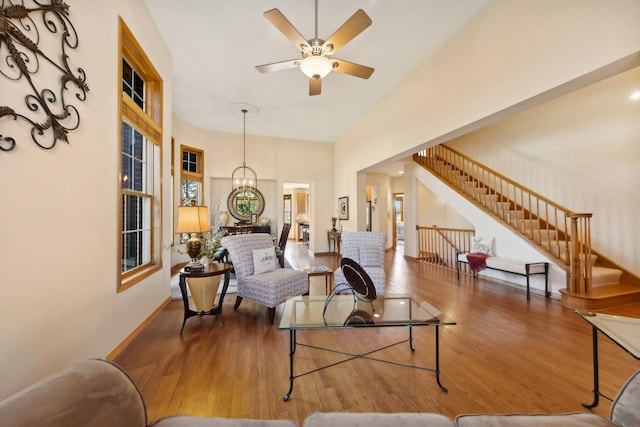 living room with wood-type flooring and ceiling fan with notable chandelier