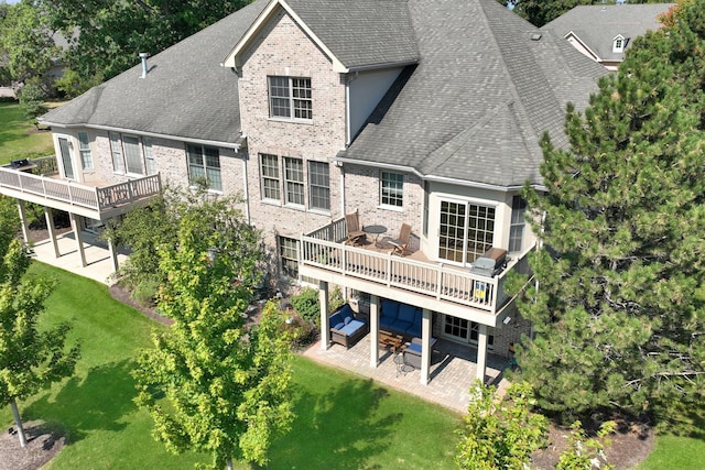 rear view of house with a wooden deck, an outdoor hangout area, a patio area, and a lawn