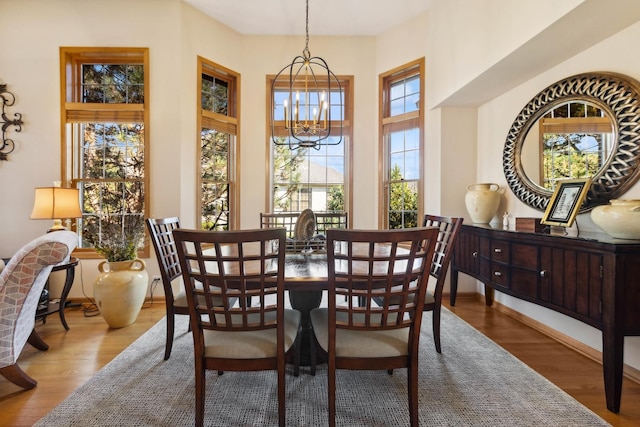 dining room with hardwood / wood-style flooring and an inviting chandelier