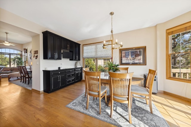 dining space featuring ceiling fan with notable chandelier and light hardwood / wood-style flooring